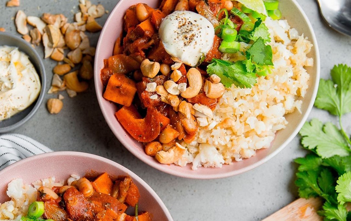 two bowls of vegetarian chilli with rice and green garnish.